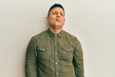 Gündelik giysiler giymiş genç Latin bir adam kameraya bakıyor. Canlı yayında öpücük yolluyor. Güzel ve seksi. aşk ifadesi. 