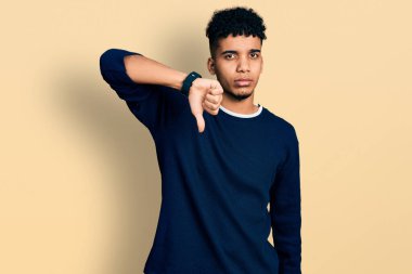 Genç Afro-Amerikalı sıradan kıyafetler giyen mutsuz, kızgın, reddedilmiş ve olumsuz hareketler yapan genç bir adam. kötü ifade. 
