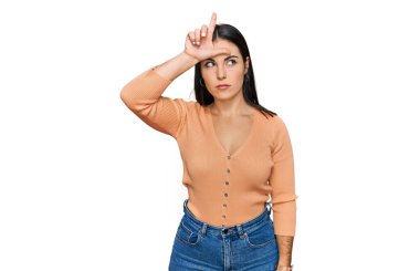 Genç İspanyol kadın günlük kıyafetler giyiyor. Alnında parmakları olan insanlarla alay ediyor. Ezik hareketler yapıyor, alay ediyor.. 