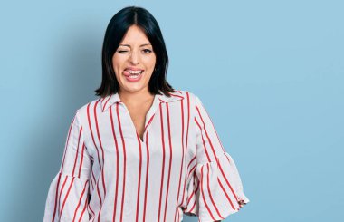 Gündelik kıyafetler giyen genç İspanyol kız kameraya seksi bir ifadeyle bakıyor, neşeli ve mutlu bir yüzle.. 