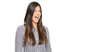 Kış süveteri giyen genç esmer kadın kameraya seksi bir ifadeyle bakıyor, neşeli ve mutlu bir yüzle.. 