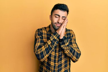 Gündelik kıyafetler giyen genç İspanyol adam uyur. Yorgun düşler kurar, ellerle poz verir, gözleri kapalı gülümserdi.. 