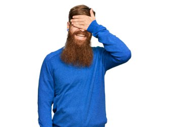 Genç İrlandalı kızıl elbiseli, sıradan giyinmiş, gülümseyen ve elleri yüzünde, şaşırtmak için gözleri kapatan bir adam. kör kavram. 