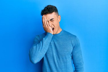 Sıradan bir kazak giyen İspanyol genç adam yarı yüzünü, göz ve ağzını eliyle kapatmaktan yorulmuş. Yüzüm acıyor.. 