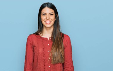 Yüzünde mutlu ve havalı bir gülümseme olan gündelik kıyafetler giyen genç İspanyol kadın. şanslı kişi. 