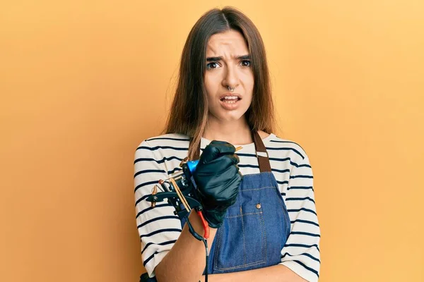 Junge Hispanische Tätowiererin Berufskleidung Und Handschuhen Ahnungslos Und Verwirrt Zweifelhaftes — Stockfoto