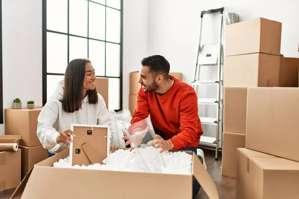 Joven Pareja Latina Sonriendo Feliz Unboxing Caja Cartón Nuevo Hogar — Foto de Stock