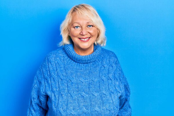 Middle age blonde woman wearing casual clothes with a happy and cool smile on face. lucky person. 