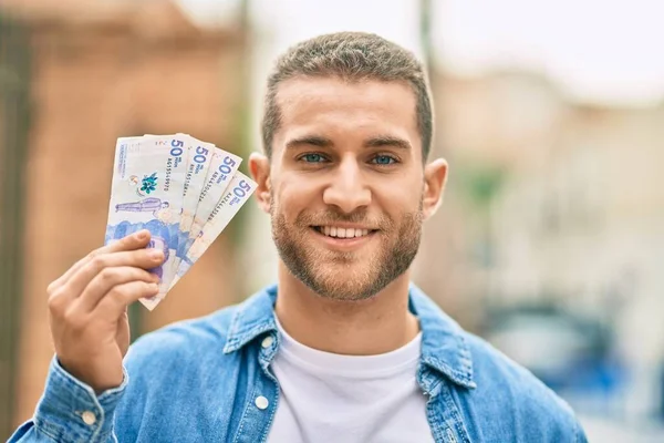 Jovem Caucasiano Sorrindo Feliz Segurando Pesos Colombianos Cidade — Fotografia de Stock