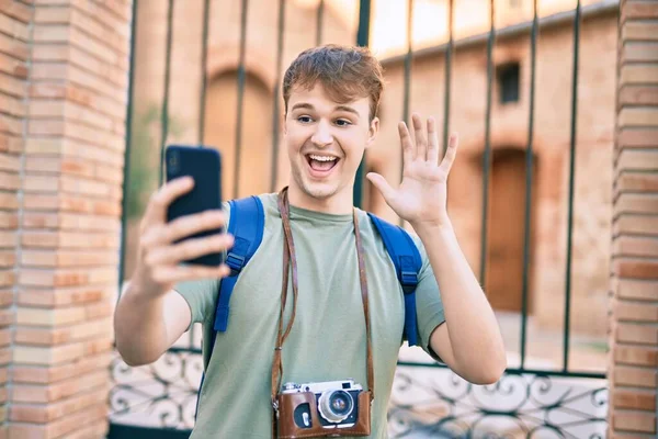 若いです白人観光客の男を行うビデオ通話を使用してスマートフォンで市内 — ストック写真