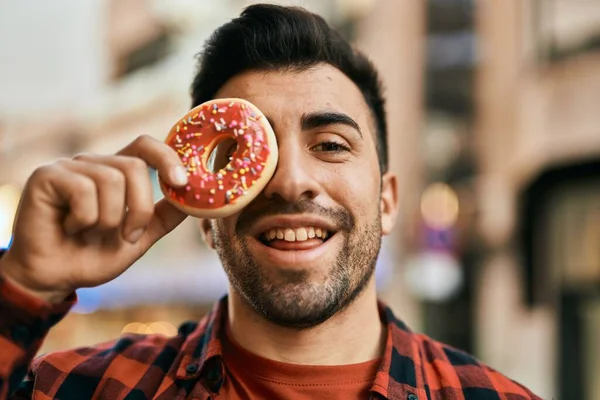Νεαρός Ισπανός Χαμογελά Χαρούμενος Κρατώντας Ντόνατ Πάνω Από Μάτι Στην — Φωτογραφία Αρχείου