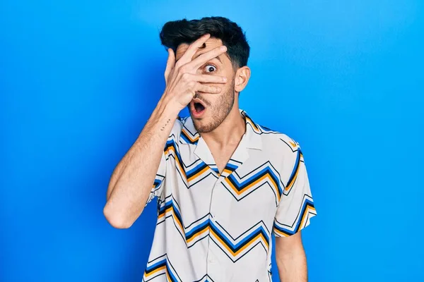 Young Hispanic Man Wearing Casual Clothes Peeking Shock Covering Face — Stock Photo, Image