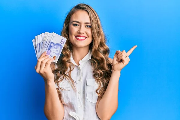 Joven Chica Rubia Sosteniendo Billetes Coronas Suecas Sonriendo Feliz Señalando — Foto de Stock