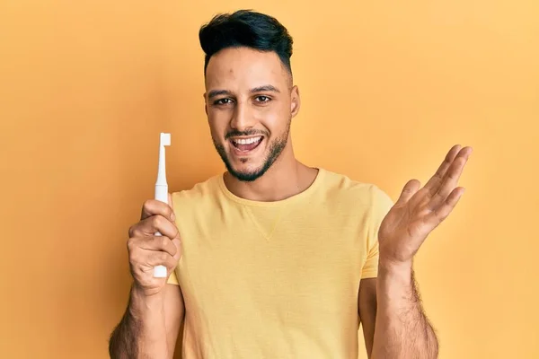 Jeune Homme Arabe Tenant Une Brosse Dents Électrique Célébrant Réalisation — Photo