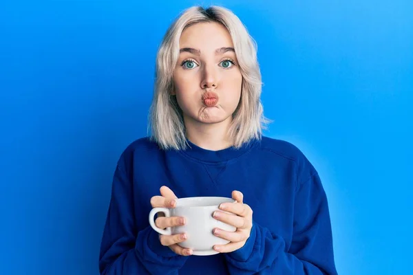 Young Blonde Girl Drinking Cup Coffee Puffing Cheeks Funny Face — Stock Photo, Image