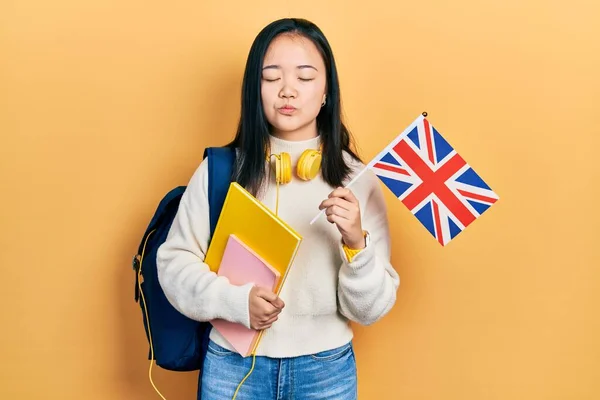 Młoda Chińska Dziewczyna Wymiany Studentów Trzymając Flagi Patrząc Aparat Dmuchanie — Zdjęcie stockowe