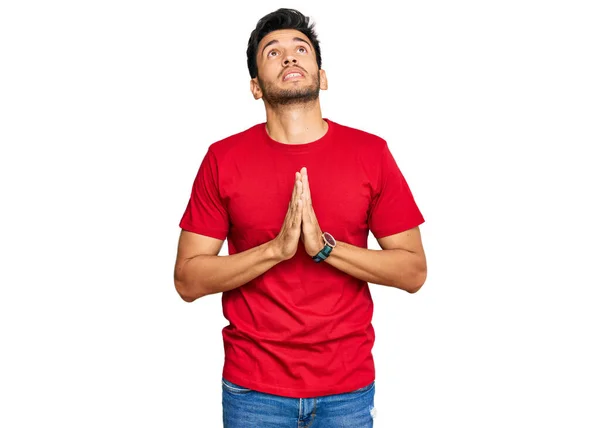 Νεαρός Όμορφος Άνδρας Φορώντας Casual Κόκκινο Μπλουζάκι Επαιτεία Και Προσεύχεται — Φωτογραφία Αρχείου