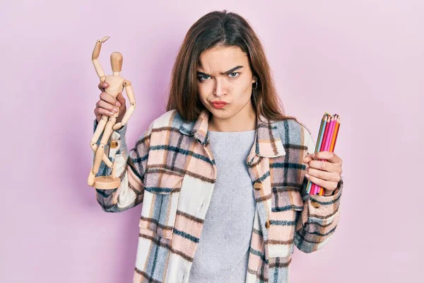 Menina Caucasiana Jovem Segurando Pequeno Manequim Madeira Lápis Cético Nervoso — Fotografia de Stock