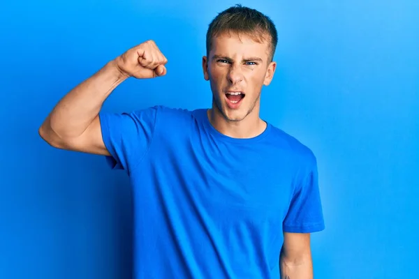 Joven Hombre Caucásico Vistiendo Casual Camiseta Azul Enojado Loco Levantando — Foto de Stock