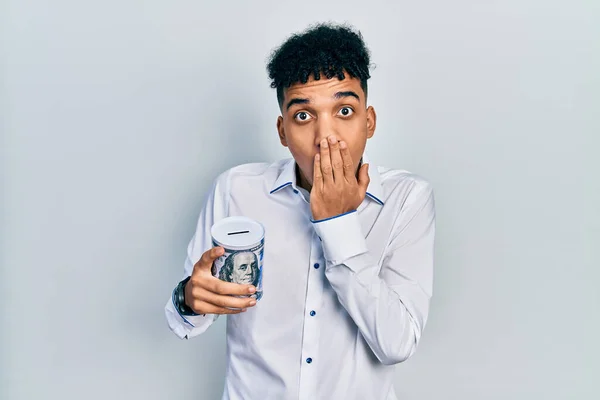 Jovem Afro Americano Segurando Banco Porquinho Cobrindo Boca Com Mão — Fotografia de Stock