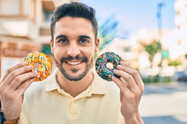 Jeune Homme Hispanique Souriant Heureux Tenant Beignets Marchant Ville — Photo