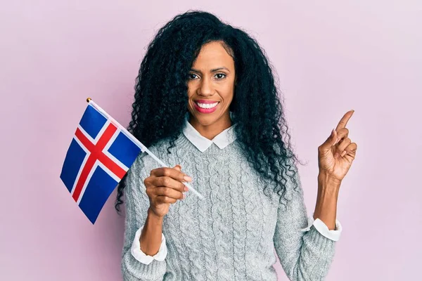 中年非洲裔美国妇女举着法国国旗 高兴地微笑着 手指手画脚地指向旁边 — 图库照片