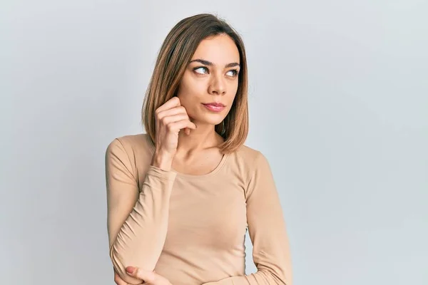 가볍게 스웨터를 금발의 여성은 손가락을 올려다보며 의심하는 — 스톡 사진