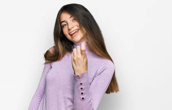 터틀넥 스웨터를 손짓하는 아름다운 소녀가 행복하고 미소짓는 환영하는 손짓으로 자리에 — 스톡 사진