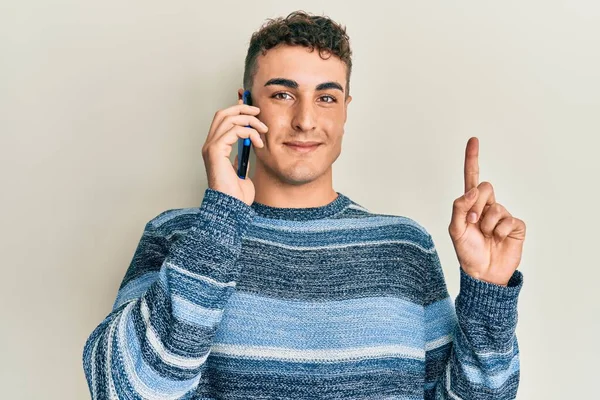 幸せな顔をしたアイデアや質問を指差す指で話しているスマートフォンで会話をしているヒスパニック系の若者 ナンバーワン — ストック写真