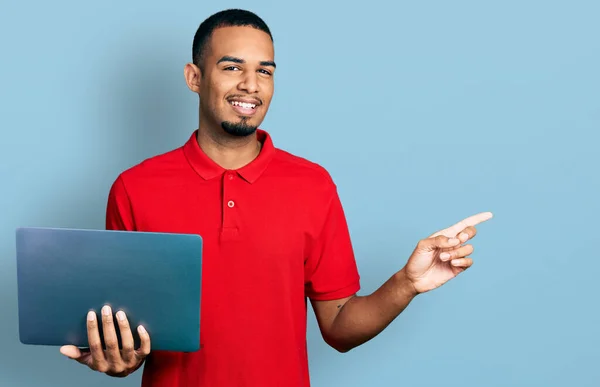 Молодой Афроамериканец Работающий Компьютере Улыбается Показывая Пальцем Рукой Сторону — стоковое фото
