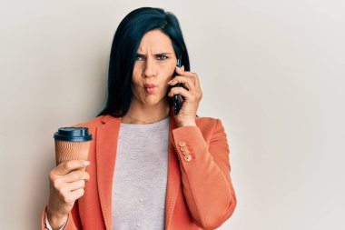 Kafkasyalı genç bir kadın elinde akıllı telefonla konuşuyor kahveyi alıp götürüyor ağzıyla balık suratı yapıyor ve şaşı bakıyor, çılgın ve komik.. 