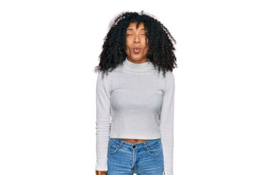 Genç Afro-Amerikan kızı günlük kıyafetler giyip dudaklarıyla balık suratı yapıyor, çılgınca ve komik bir jest. Komik ifade. 