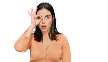 Gündelik kıyafetler giyen genç İspanyol kadın şaşırmış yüz ifadesiyle şok olmuş, parmaklarından bakan gözler. İnançsız ifade. 