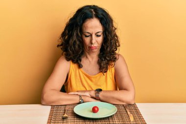 Diyet yapan, şüpheci ve gergin orta yaşlı güzel bir kadın sorun yüzünden surat asıyor. negatif kişi. 