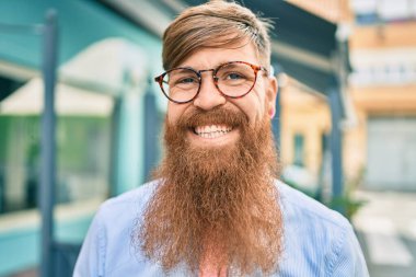 Uzun sakallı, genç, kızıl saçlı işadamı şehire doğru mutlu adımlarla yürüyordu..