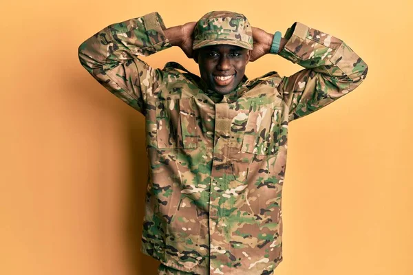 軍の制服を着た若いアフリカ系アメリカ人の男がリラックスしてストレッチ 腕と手を頭と首の後ろに笑顔幸せ — ストック写真