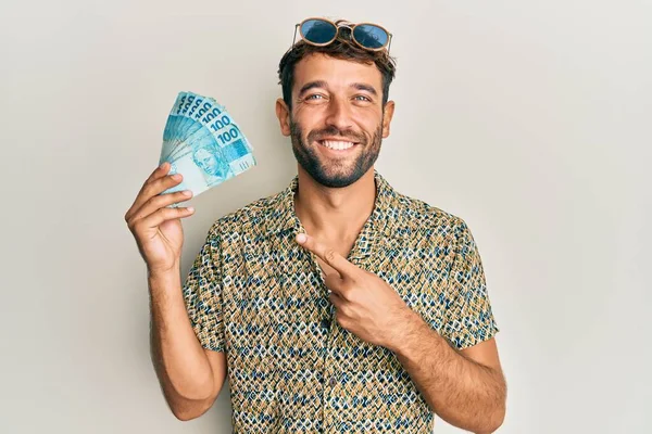 Hombre Guapo Con Barba Sosteniendo 100 Billetes Reales Brasileños Sonriendo —  Fotos de Stock