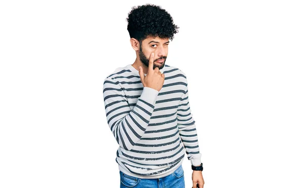 若いですアラブ人男で髭を生やしてカジュアルなストライプセーターを身に着けていますあなたのジェスチャーを見ます 怪しい表情 — ストック写真