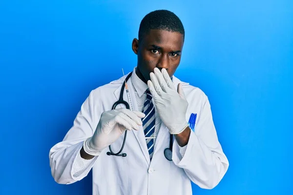 Joven Médico Afroamericano Sosteniendo Jeringa Cubriendo Boca Con Mano Sorprendido — Foto de Stock