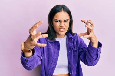 Genç esmer kadın, gündelik giysiler içinde öfkeyle bağırıyor, elleri boğazlamaya çalışıyor, deli gibi bağırıyor. 