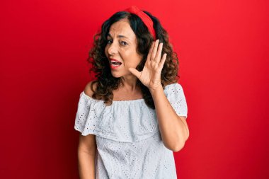 Orta yaşlı İspanyol kadın, günlük giysiler giyip, sırıtarak dedikodu ve dedikoduları dinliyor. Sağırlık kavramı. 