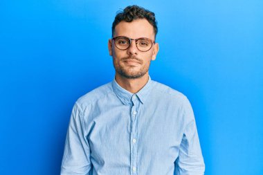 Günlük kıyafetler ve gözlük takan genç İspanyol adam yüzünde ciddi bir ifadeyle rahatladı. Basit ve doğal bir şekilde kameraya bakıyorsun.. 