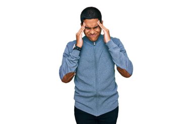 Genç, yakışıklı, İspanyol bir adam, sıradan bir kazak giyiyor, elleri kafasında, stresten baş ağrısı çekiyor. migren ağrısı. 