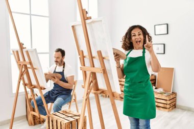 İspanyol orta yaşlı kadın ve sanat stüdyosundaki olgun adam bir fikre ya da soru işaretine şaşırdılar. 