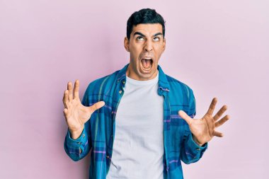 Yakışıklı, sıradan kıyafetler giyen deli deli deli bağıran, agresif bir ifade ve kollarla bağıran bir İspanyol. hüsran kavramı. 