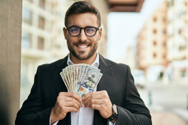 Genç İspanyol işadamı gülümseyerek şehirde Amerikan doları tutuyor..