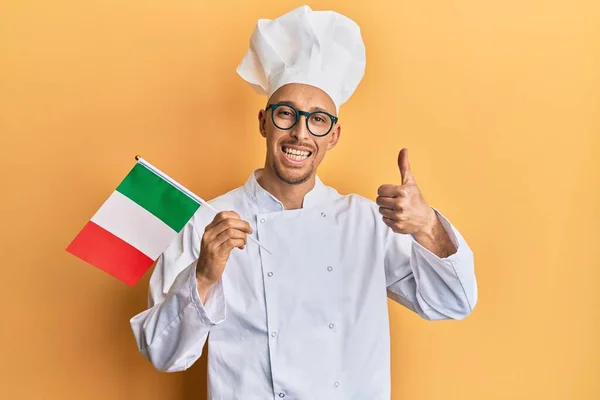 Plešatý Muž Plnovousem Profesionální Kuchařské Uniformě Drží Italskou Vlajku Úsměvem — Stock fotografie