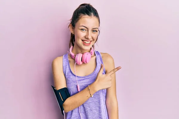 Jonge Brunette Vrouw Draagt Sportkleding Koptelefoon Glimlachend Vrolijk Wijzend Met — Stockfoto