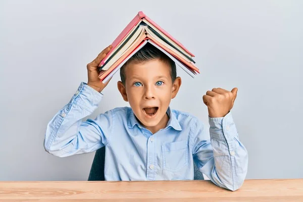 Adorable Niño Caucásico Sosteniendo Libro Cabeza Apuntando Pulgar Hacia Lado — Foto de Stock