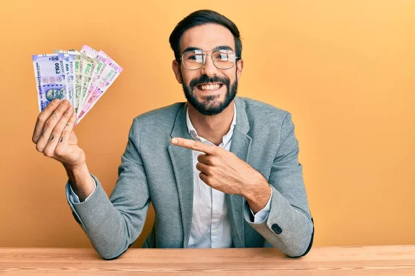 Joven Hispano Sosteniendo Billetes Rupias Indias Sentado Mesa Sonriendo Feliz —  Fotos de Stock